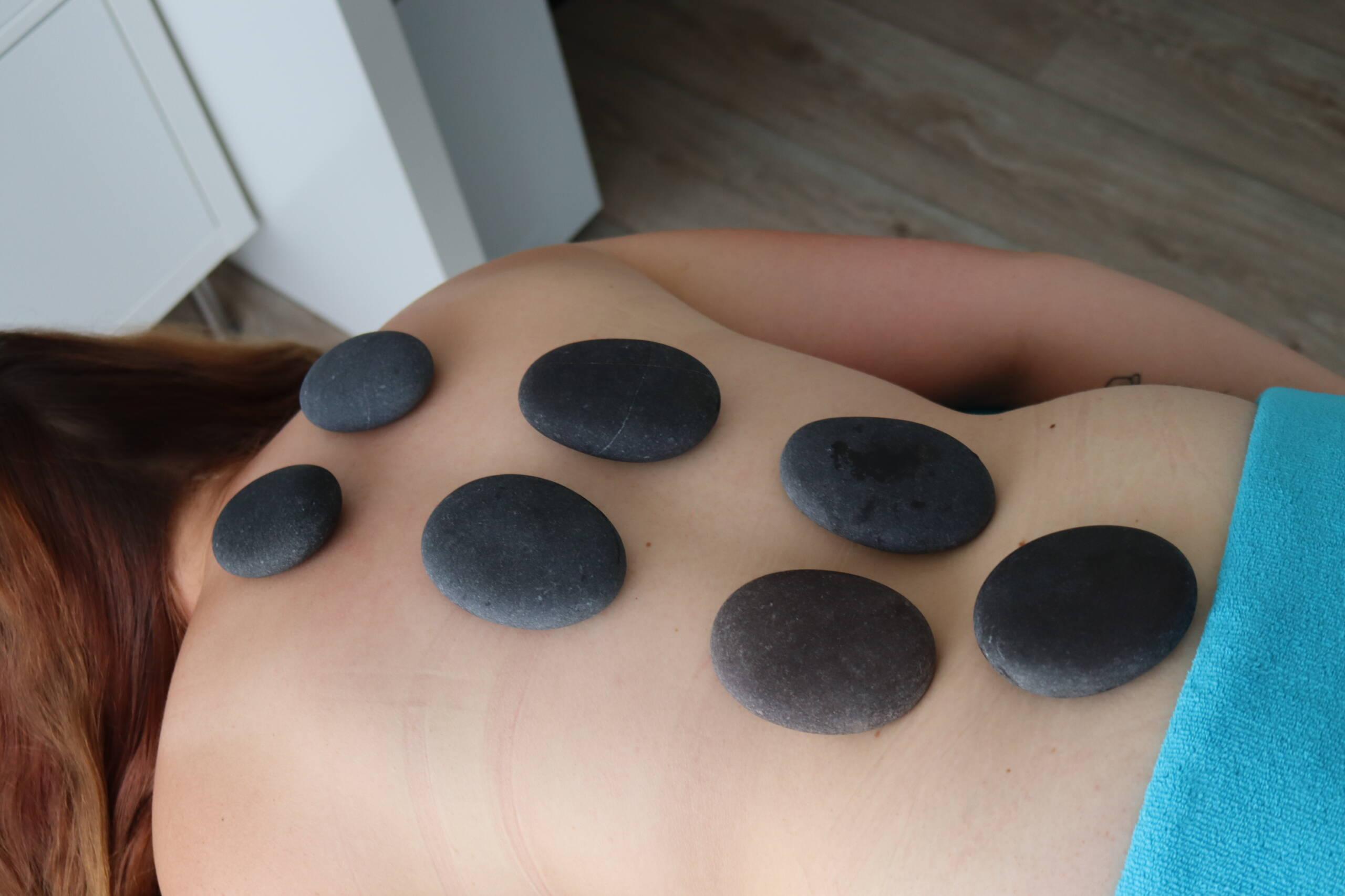 Hot stone massage en een magnesium boost 1 Hot stones op de rug, verwennerij, hot stone massage in combinatie met magnesium, welzijn, pure ontspanning, hot stone massage en een magnesium boost